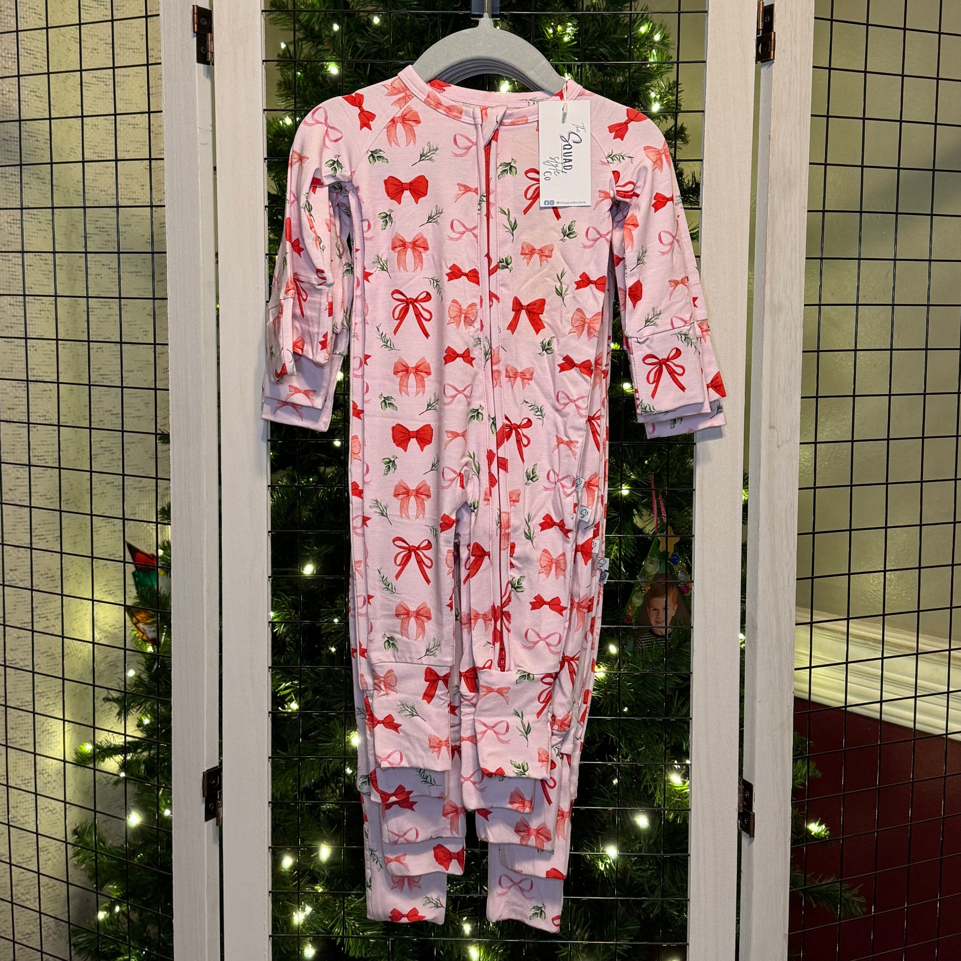 Perfectly wrapped romper hanging in front of a christmas tree