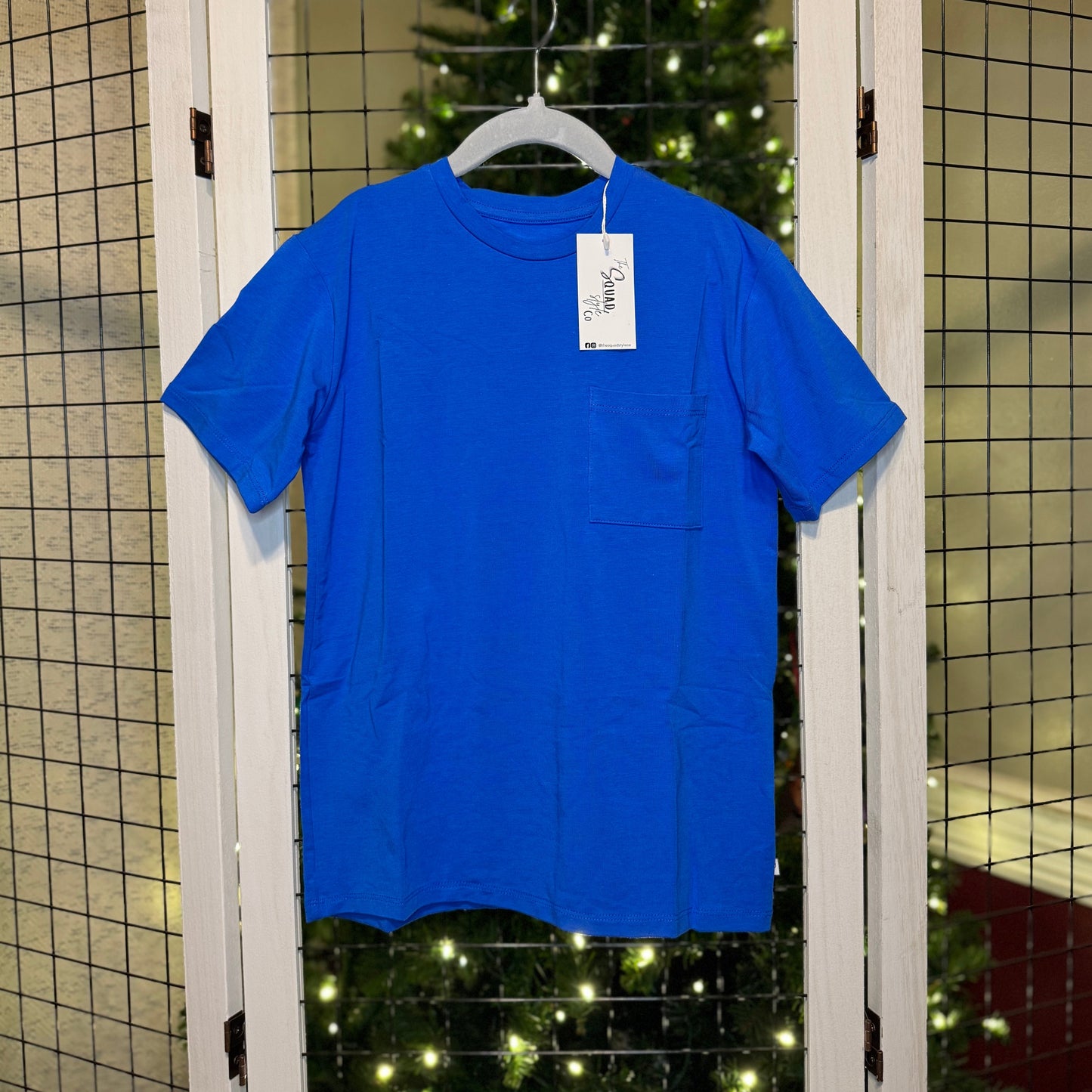 Blue t-shirt hanging with a Christmas tree in the background