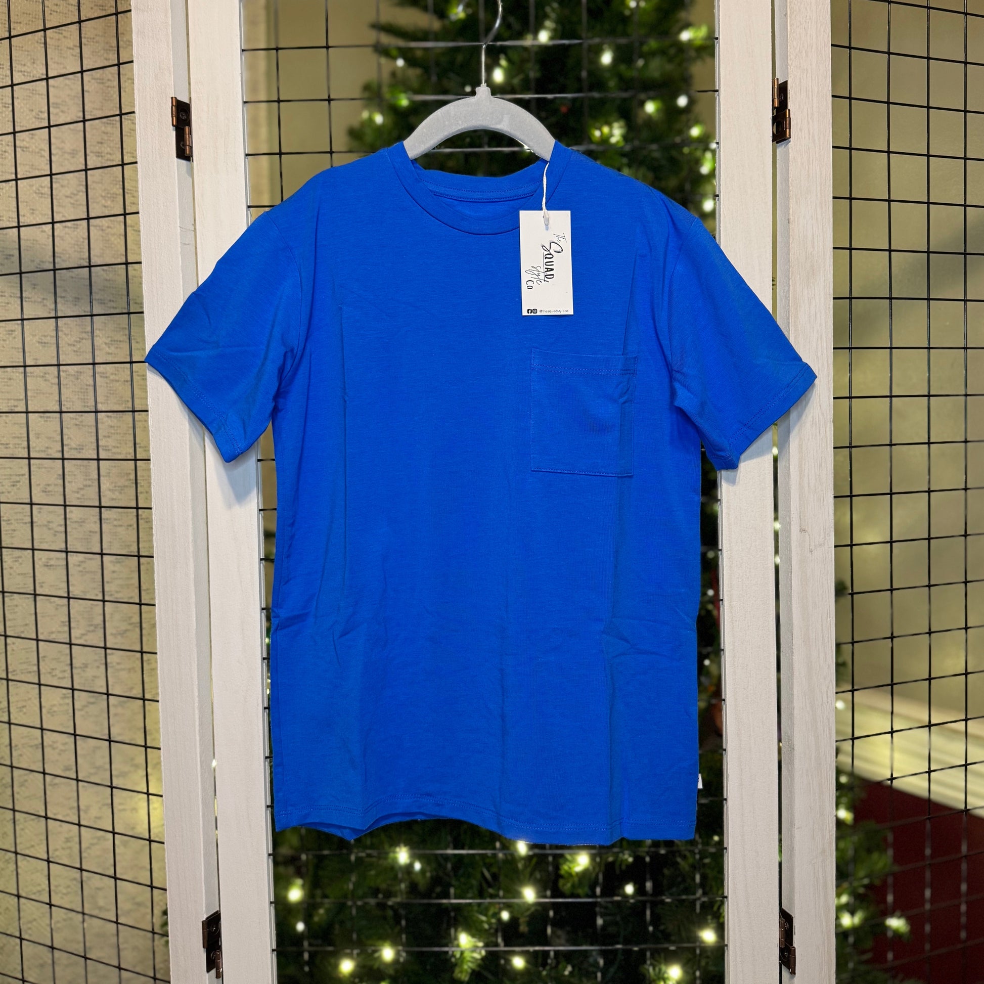 Blue t-shirt hanging with a Christmas tree in the background
